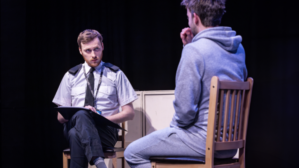 Ross Stephenson as a policeman in an interview with a suspect