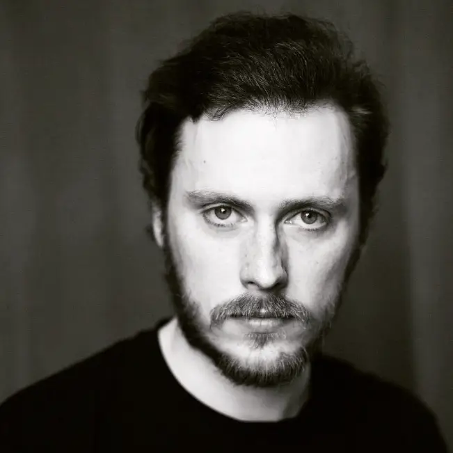 A black and white head shot of Ross Stephenson looking forwards at the camera